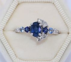 This Enchanting Ring features an oval shape 1.2 carat Blue Sapphire. Flanked by .30 carat 2 shiny deep blue sapphires, .20 carat aqua color 2 sapphires, .40 carat 7 Ice Gray Diamonds. Set in 14k white gold. Can be custom made in rose or yellow or white gold. Please choose the gold color at checkout. OOAK (one-of-a-kind) ring makes you the owner of something that nobody else has. Find your true style! Own this ring! Ethical Sourcing: This ring has a natural, ethically-sourced stones and recycled Half Moon Engagement Ring, Moon Halo, Moon Engagement Ring, Engagement Ring Custom, Marquise Engagement Ring, Crescent Ring, Ring Pop, Custom Wedding Band, Engagement Rings Marquise