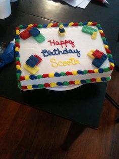 a birthday cake with legos on it and happy birthday scotty written on the side