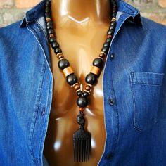 Wood bead necklace with a hand-carved African Wooden Comb  pendant. The African Wood Comb is not just an accessory but a cultural icon. ~  BEAD LENGTH ~ 28" - 71cm ~ D E T A I L S ~ ~  14mm black rustic wood beads ~  20mm black rustic wood beads ~  dark brown wood beads ~  African wood comb pendant ~  pendant - 3 1/2"  (9cm) ~  the pendant is hand carved so it  .  may differ slightly from the picture ~  lobster clasp ~  handmade ~ S H I P P I N G ~ Please see the Announcement on our shop Artisan Wooden Beads Pendant Jewelry, Ebony Jewelry With Wooden Beads For Gifts, Ebony Jewelry With Wooden Beads As A Gift, Artisan Black Necklace With 108 Beads, Unique Wooden Beads Jewelry For Meditation, Brown Jewelry With Black Beads For Festival, Festival Brown Jewelry With Black Beads, Handmade Ebony Necklaces For Gifts, Traditional Brown Beaded Necklaces With Black Beads