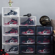 a stack of plastic boxes with various pairs of shoes on top of each one and a basketball ball in the middle