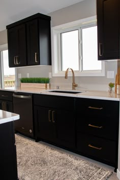 a kitchen with black cabinets and white counter tops