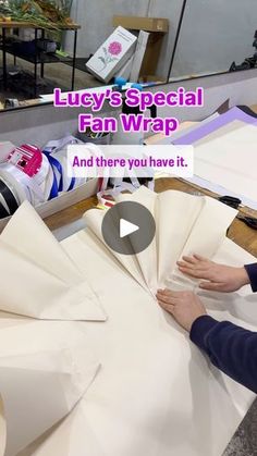 a woman is making white paper with her hands on the table and text that reads, lady's special fan wrap and there you have it