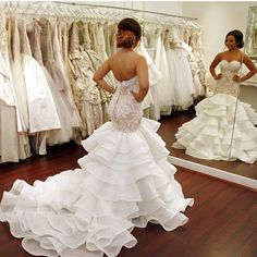 a woman is looking at her wedding dress in the mirror