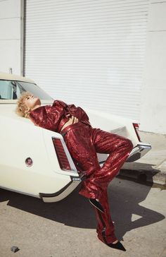 a woman leaning on the back of a white car