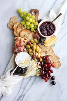 an instagram with grapes, crackers, cheese and other food items on it