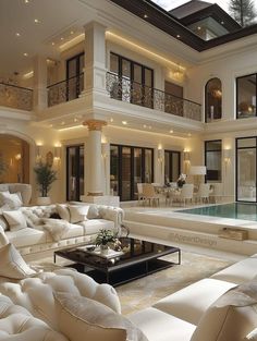 a living room filled with furniture and a swimming pool in front of a large house