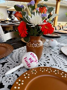 a vase with flowers and an egg sitting on a table set for easter dinner or brunch