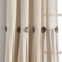 a curtain with buttons on it in front of a window