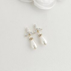 Delicate Flower Pearl Earrings for Brides: Timeless Elegance for Your Wedding Day. Explore these simple and elegant flower pearl earrings that are perfect for brides. These earrings add a touch of timeless elegance for the bride seeking a minimal yet impactful bridal look on her wedding day. These simple flower earrings will be a seamless match with any wedding dress design and style. The floral and pearl drop earrings are crafted with a sparkly clear cubic zirconia floral ear top with lustrous Flower Pearl Earrings, Simple Pearl Earrings, Bridal Party Dress, Poetry Design, Minimalist Bride, Simple Pearl, Matching Jewelry, Bridal Look, Timeless Gifts