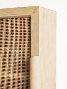 a close up of a wooden cabinet with a rattan pattern on the front and side