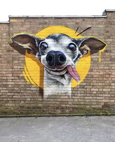 a brick wall with a painting of a dog sticking its tongue out