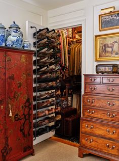 an antique dresser and armoire in a room with paintings on the walls, drawers, and other items