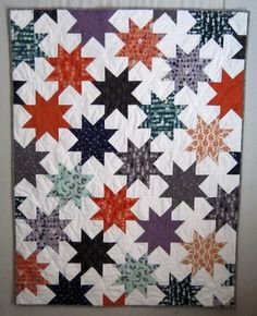 a quilted wall hanging with stars on it