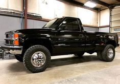 a large black truck parked in a garage