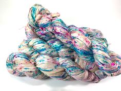 several skeins of dyed yarn are stacked on top of each other in different colors