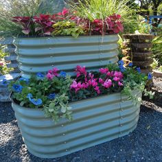 a metal planter filled with lots of flowers