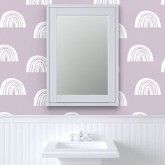 a white sink sitting under a bathroom mirror next to a wall mounted faucet