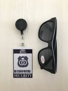 a pair of sunglasses and badge hanging on a wall