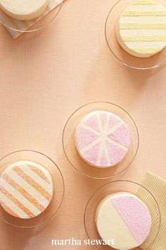 three desserts in small glass dishes on a pink tablecloth with white and yellow striped napkins