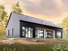 a small black house sitting on top of a grass covered field next to trees and rocks