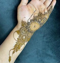 a woman's hand with henna tattoos on her left arm and the wrist