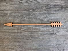 an arrow shaped wooden object sitting on top of a table