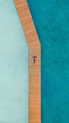 an aerial view of a dock with a person standing on it and looking down at the water