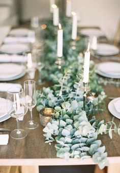 the table is set with candles, plates and succulents for an elegant touch