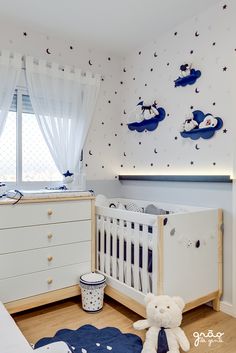 a baby's room is decorated in blue and white with stars on the wall