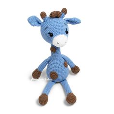 a crocheted giraffe stuffed animal sitting up against a white background