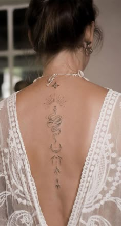 the back of a woman's neck with tattoos on her upper and lower back