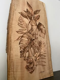 a piece of wood with flowers and leaves on it