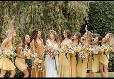 a group of women standing next to each other holding bouquets in their hands and laughing