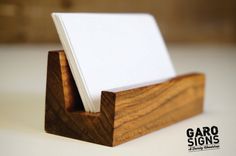 a business card holder made out of wood and white cards on it's sides