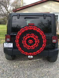 a black jeep with red chains on it's rear window and the back tire