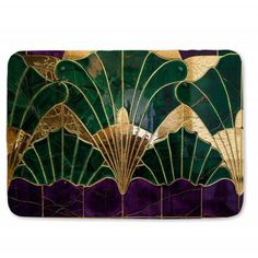 a green and gold art deco tile with fan shaped designs on the front, along with purple background