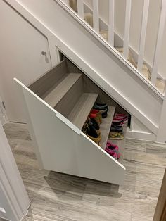 an under the stairs shoe rack with shoes in it