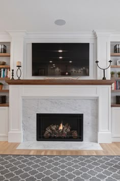 a living room with a fire place and bookshelves on the wall above it