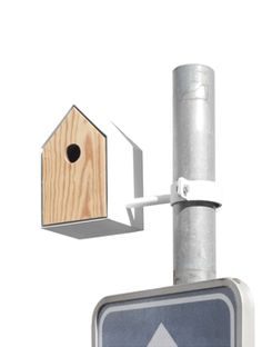 a birdhouse mounted to the side of a pole