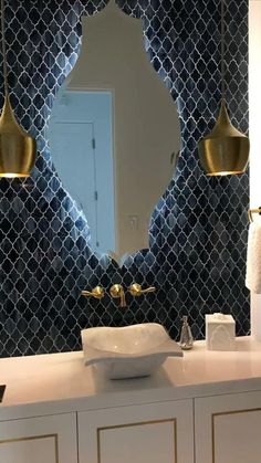 a white sink sitting under a bathroom mirror next to a wall mounted faucet