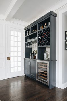 a wine rack in the corner of a room with an open door and shelves on both sides