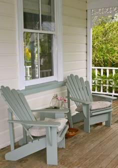 two adiron chairs are sitting on the porch