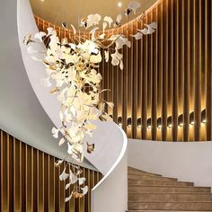 an elegant chandelier hangs from the ceiling in front of a spiral stair case