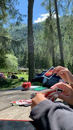 two people sitting at a picnic table in the woods