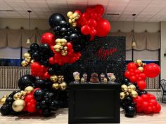 an arrangement of black, red and gold balloons