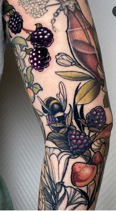 a woman's arm with fruit and flowers on it