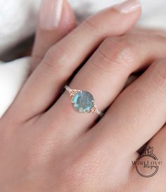 a woman's hand with a ring on it and a blue stone in the middle