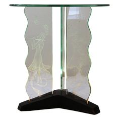 a glass table with an artistic design on the top and bottom part, along with a black base