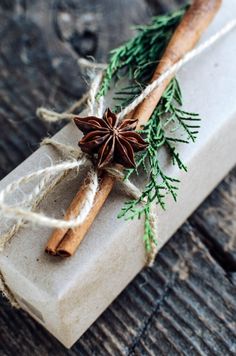 two cinnamon sticks wrapped in twine and tied with twine on top of a white box