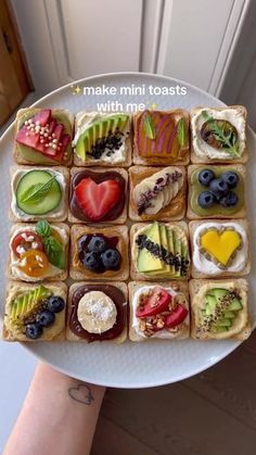 a white plate topped with sandwiches covered in fruit and vegtables on top of each other